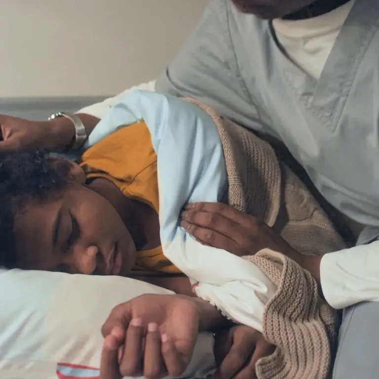 Caregiving child being covered with blanket