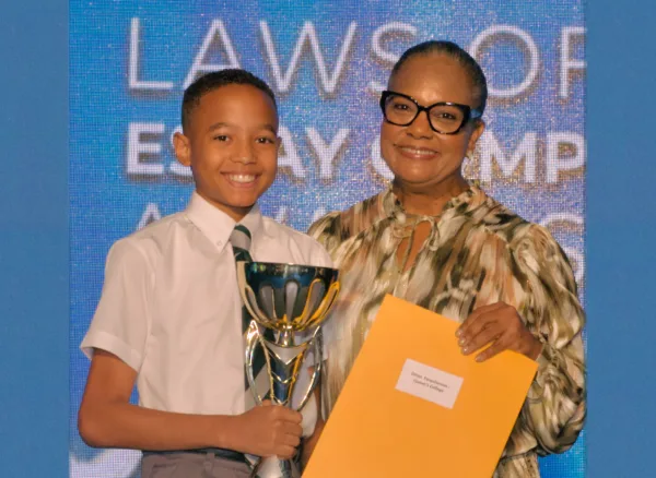 The Bahamas Laws of Life Essay and Video Competition 2024 - Ethan Farquharson of Queen’s College - Top Scorer in Junior Division - Overall Winner of the 2024 Laws of Life Essay Competition Receives his prize from TWCF President, Tina Cambridge.